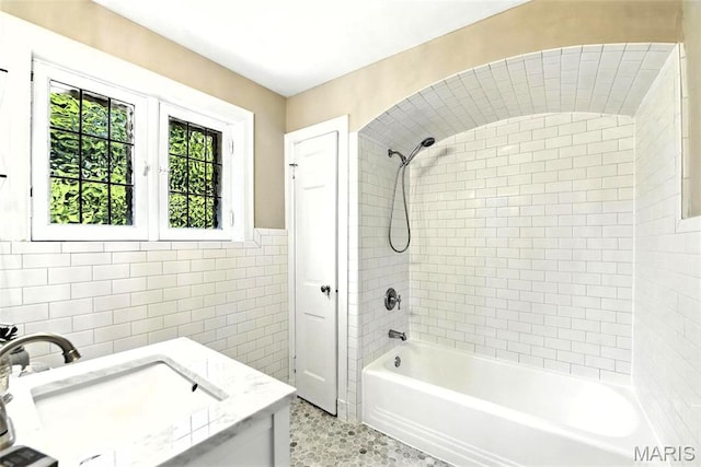 8049 Gannon Ave, Saint Louis, MO 63130 - bathroom featuring tile walls, vanity, bathtub / shower combination, and a wainscoted wall