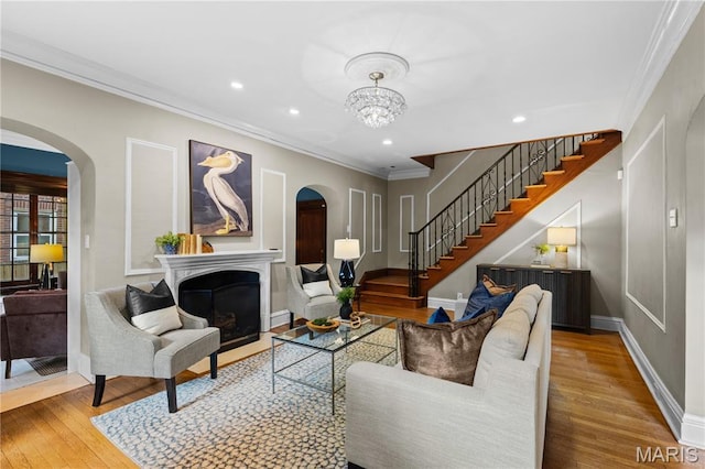 316 Melville Ave, University City, MO 63130 - living area with arched walkways, stairway, wood finished floors, a fireplace, and ornamental molding