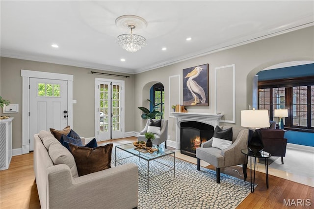316 Melville Ave, University City, MO 63130 - living room featuring arched walkways, ornamental molding, wood finished floors, a warm lit fireplace, and recessed lighting