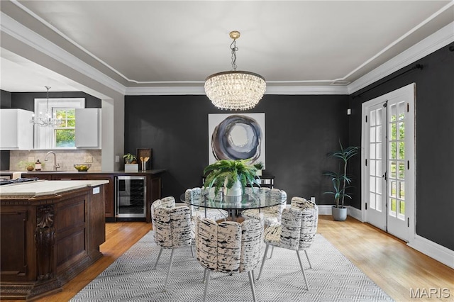 316 Melville Ave, University City, MO 63130 - dining area with beverage cooler, a chandelier, light wood-type flooring, and ornamental molding