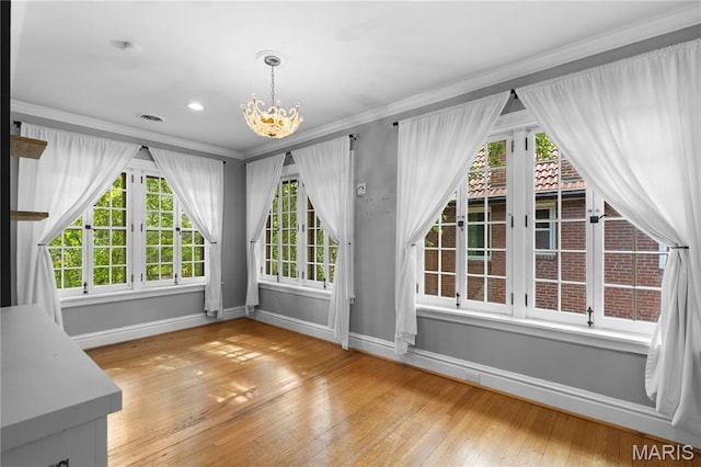316 Melville Ave, University City, MO 63130 - unfurnished dining area with a chandelier, plenty of natural light, wood-type flooring, and ornamental molding