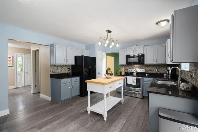 269 Sassafras Parc Dr, Ofallon, MO 63368 - kitchen featuring black appliances, backsplash, a chandelier, dark wood-type flooring, and decorative light fixtures