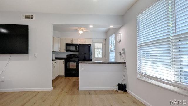 1669 Mayenne Ct Unit B, Mehlville, MO 63125 - kitchen featuring black appliances, light wood-type flooring, dark countertops, a ceiling fan, and white cabinetry