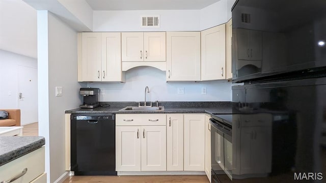 1669 Mayenne Ct Unit B, Mehlville, MO 63125 - kitchen with black appliances, dark countertops, light wood-style floors, and white cabinets