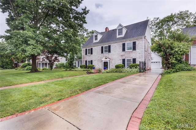 220 Orrick Ln, Kirkwood, MO 63122 - view of front of property with a chimney, a front yard, brick siding, and a detached garage
