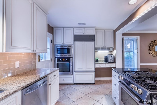 220 Orrick Ln, Kirkwood, MO 63122 - kitchen featuring built in appliances, healthy amount of natural light, white cabinetry, decorative backsplash, and ornamental molding