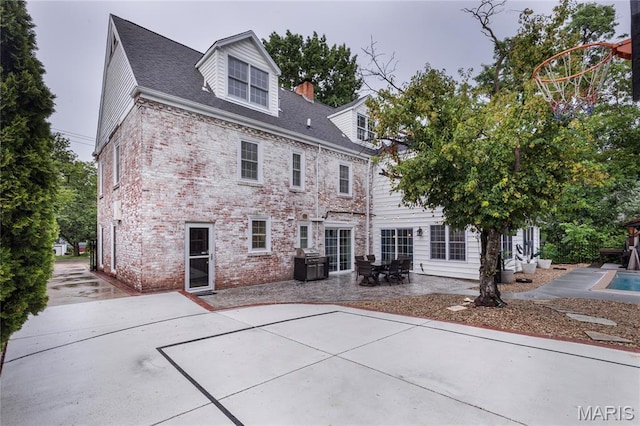 220 Orrick Ln, Kirkwood, MO 63122 - rear view of house with brick siding, a patio area, and a chimney