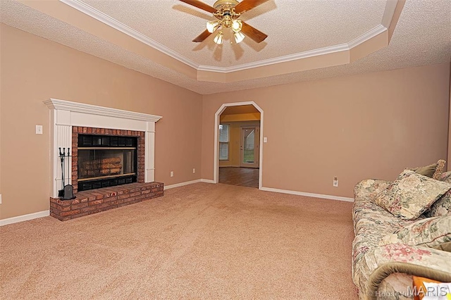643 Woodgate St, Farmington, MO 63640 - carpeted living area featuring a textured ceiling, a tray ceiling, crown molding, ceiling fan, and a fireplace