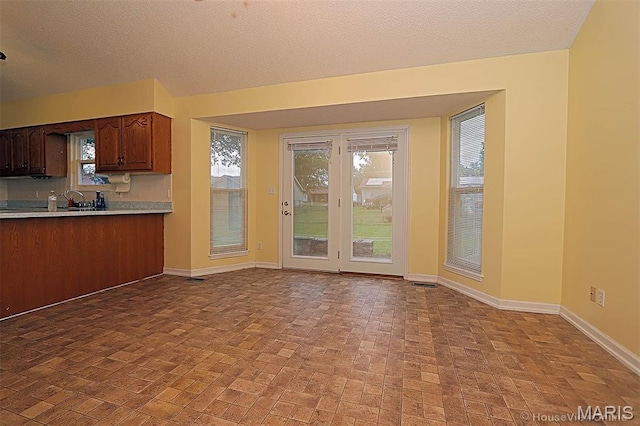 643 Woodgate St, Farmington, MO 63640 - kitchen featuring light countertops, brick patterned floors, decorative backsplash, and a textured ceiling