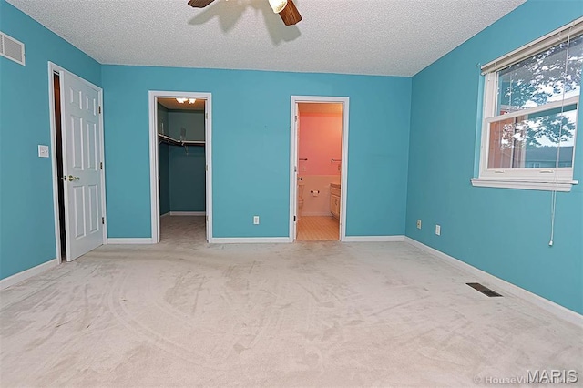 643 Woodgate St, Farmington, MO 63640 - unfurnished bedroom featuring a textured ceiling, a spacious closet, carpet flooring, a ceiling fan, and ensuite bathroom
