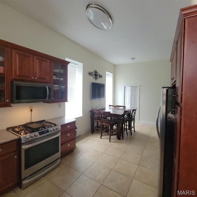 3761 Finney Ave, Saint Louis, MO 63113 - kitchen featuring appliances with stainless steel finishes, glass insert cabinets, and light tile patterned floors