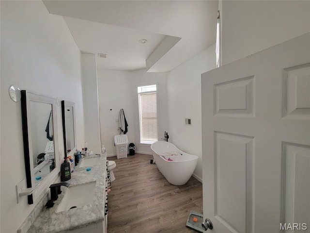 3761 Finney Ave, Saint Louis, MO 63113 - full bathroom featuring double vanity, a freestanding bath, and wood finished floors