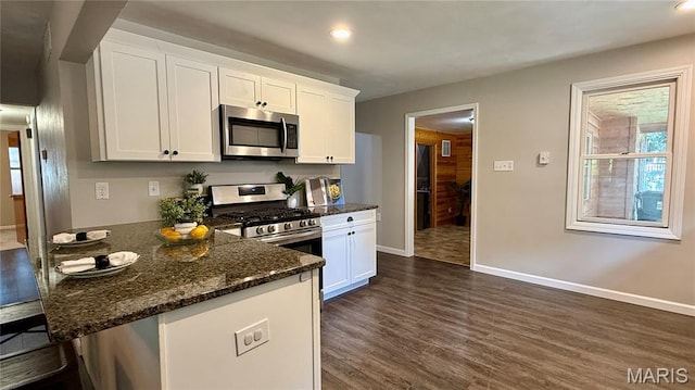504 N Moore St, Waterloo, IL 62298 - kitchen with appliances with stainless steel finishes, dark wood-type flooring, dark stone counters, white cabinets, and a peninsula