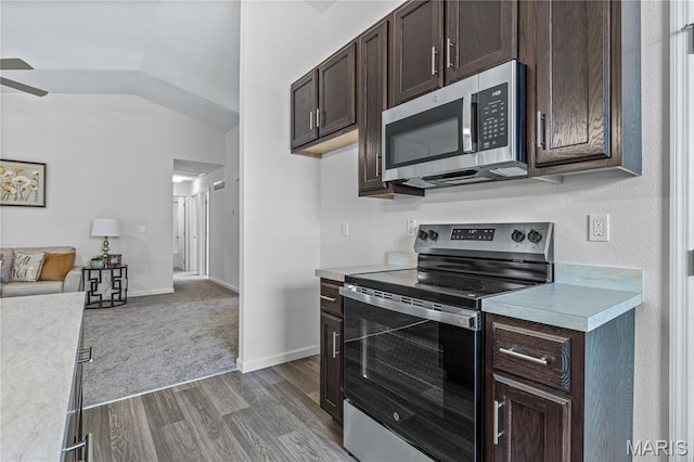 1941 Magnolia Way, Pevely, MO 63070 - kitchen featuring appliances with stainless steel finishes, light countertops, dark brown cabinets, open floor plan, and dark wood-type flooring