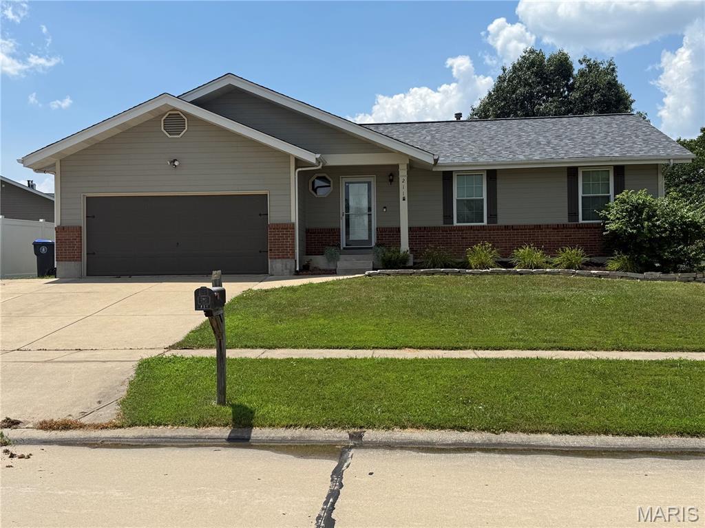 211 Surrey Ct, Ofallon, MO 63366 - ranch-style home with brick siding, an attached garage, concrete driveway, and a front yard