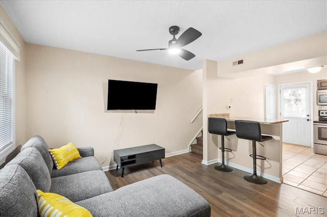 9053 W Swan Cir, Brentwood, MO 63144 - living room featuring ceiling fan, stairs, and wood finished floors