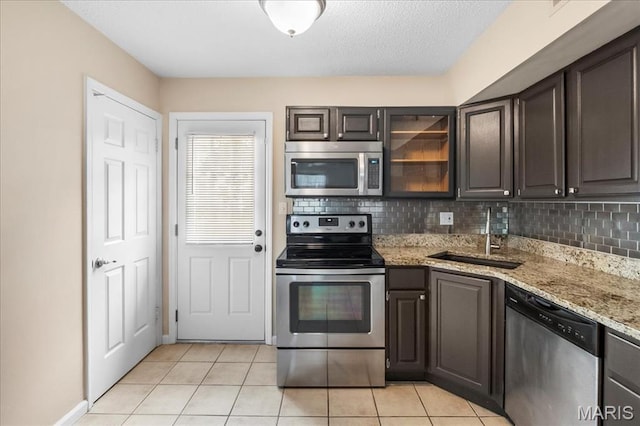 9053 W Swan Cir, Brentwood, MO 63144 - kitchen featuring stainless steel appliances, tasteful backsplash, light tile patterned flooring, and light stone countertops