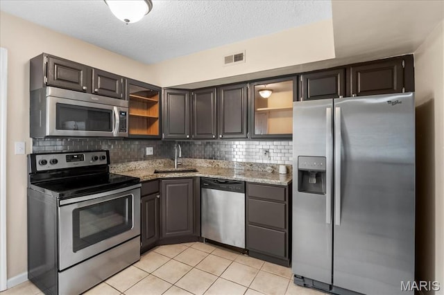 9053 W Swan Cir, Brentwood, MO 63144 - kitchen with stainless steel appliances, open shelves, light stone countertops, decorative backsplash, and a textured ceiling