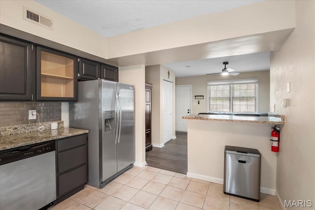 9053 W Swan Cir, Brentwood, MO 63144 - kitchen with appliances with stainless steel finishes, light stone counters, light tile patterned flooring, ceiling fan, and a textured ceiling
