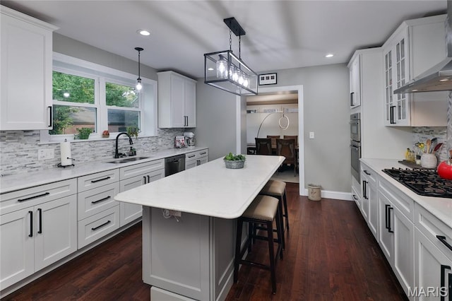 728 Yale Ave, Saint Louis, MO 63130 - kitchen featuring black appliances, wall chimney range hood, a kitchen breakfast bar, backsplash, and recessed lighting