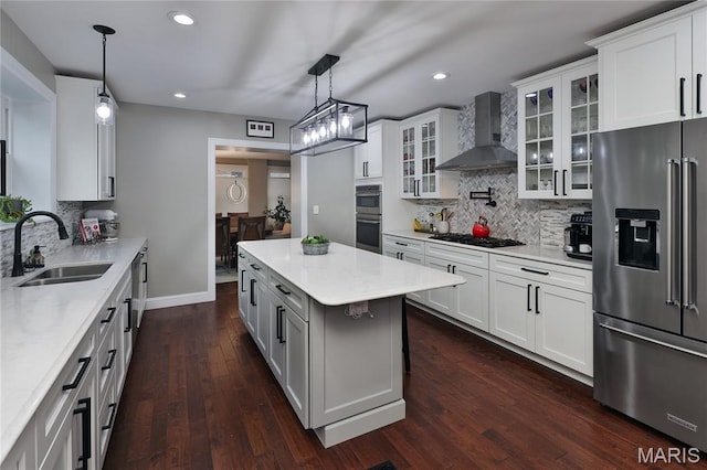 728 Yale Ave, Saint Louis, MO 63130 - kitchen featuring appliances with stainless steel finishes, wall chimney exhaust hood, backsplash, dark wood-style flooring, and recessed lighting