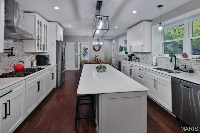 728 Yale Ave, Saint Louis, MO 63130 - kitchen with appliances with stainless steel finishes, wall chimney exhaust hood, a center island, tasteful backsplash, and glass insert cabinets