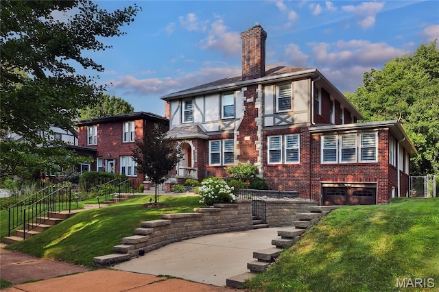 728 Yale Ave, Saint Louis, MO 63130 - back of house with brick siding, a chimney, an attached garage, a yard, and driveway
