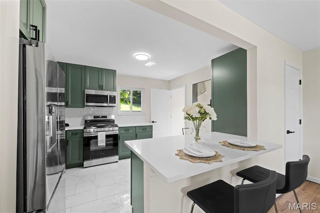 7944 Lavington Dr, Richmond Heights, MO 63117 - kitchen featuring green cabinetry, stainless steel appliances, light countertops, and a breakfast bar