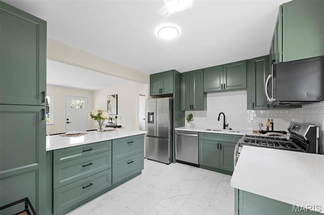 7944 Lavington Dr, Richmond Heights, MO 63117 - kitchen with green cabinetry, stainless steel appliances, and light marble finish flooring