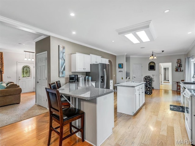 394 Sunset Echo Rd, Union, MO 63084 - kitchen with stainless steel refrigerator with ice dispenser, white cabinetry, crown molding, an island with sink, and light wood finished floors