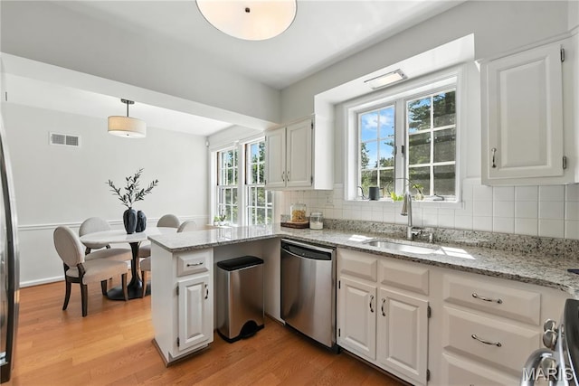 43 Highgate Rd, Olivette, MO 63132 - kitchen with stainless steel dishwasher, light wood-style flooring, and white cabinetry
