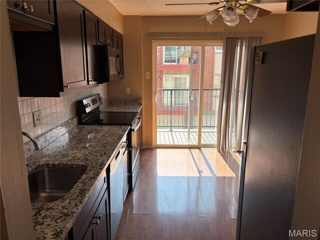 10335 Forest Brook Ln Unit C, Creve Coeur, MO 63146 - kitchen with stainless steel appliances, a ceiling fan, wood finished floors, decorative backsplash, and stone countertops
