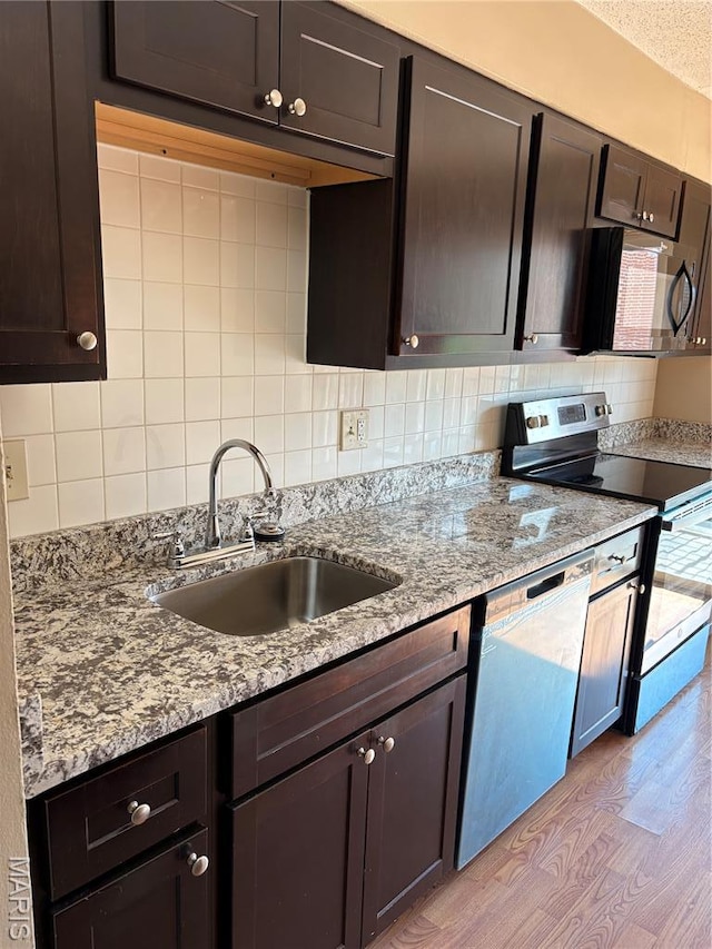 10335 Forest Brook Ln Unit C, Creve Coeur, MO 63146 - kitchen with stainless steel appliances, tasteful backsplash, light stone counters, and dark brown cabinetry