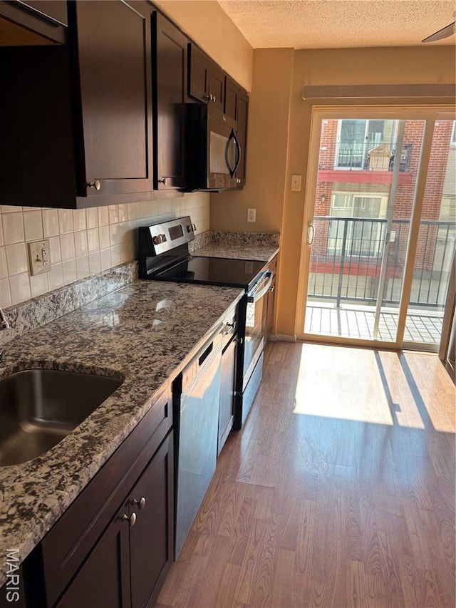 10335 Forest Brook Ln Unit C, Creve Coeur, MO 63146 - kitchen featuring stainless steel appliances, light wood finished floors, decorative backsplash, stone counters, and a textured ceiling
