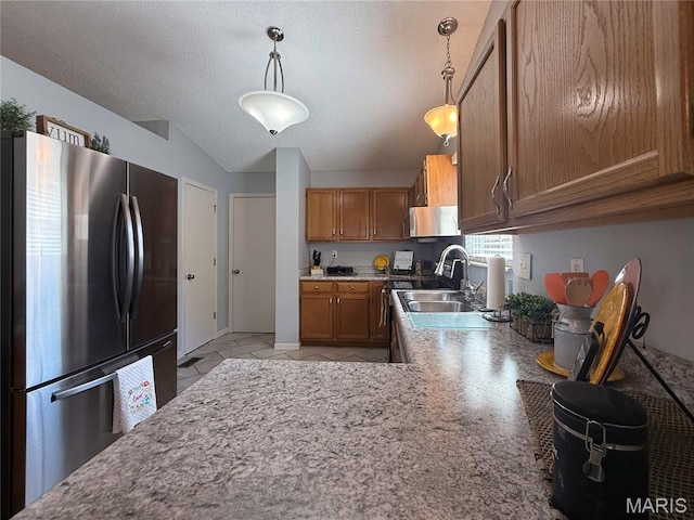 607 Apple Glen Ct, Arnold, MO 63010 - kitchen featuring freestanding refrigerator, brown cabinets, vaulted ceiling, hanging light fixtures, and a textured ceiling
