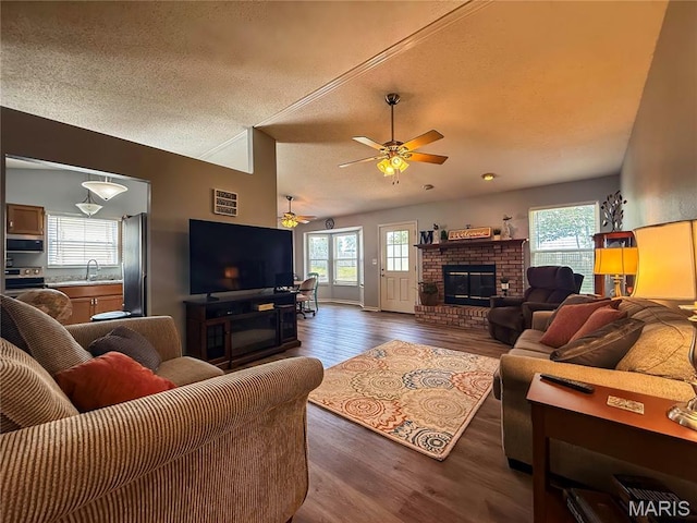 607 Apple Glen Ct, Arnold, MO 63010 - living area with dark wood finished floors, healthy amount of natural light, a ceiling fan, a brick fireplace, and a textured ceiling