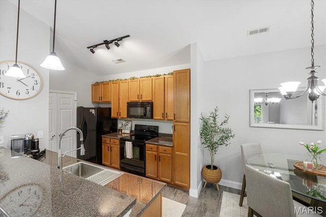 27 Kassebaum Ln Unit 302, Mehlville, MO 63129 - kitchen with black appliances, track lighting, light wood-style flooring, a chandelier, and brown cabinets
