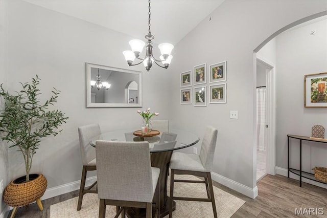 27 Kassebaum Ln Unit 302, Mehlville, MO 63129 - dining area with arched walkways, wood finished floors, a chandelier, and lofted ceiling