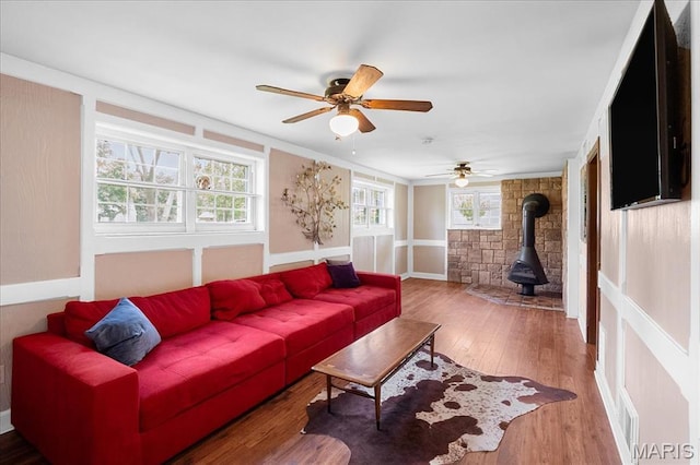 1239 Vero Ln, Ellisville, MO 63011 - living area featuring a wood stove, wood finished floors, a ceiling fan, and ornamental molding
