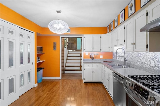 1239 Vero Ln, Ellisville, MO 63011 - kitchen with stainless steel appliances, a chandelier, white cabinets, light countertops, and light wood-style flooring