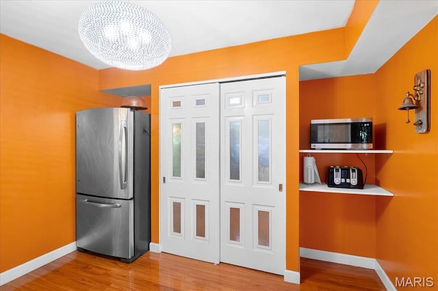 1239 Vero Ln, Ellisville, MO 63011 - kitchen with stainless steel appliances, wood finished floors, and a chandelier