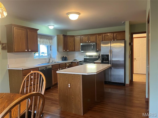 3 Boxwood Crest Ct, Ofallon, MO 63366 - kitchen with appliances with stainless steel finishes, dark wood-style floors, a kitchen island, light countertops, and tasteful backsplash