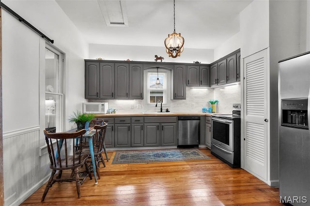 713 W Adams St, Jackson, MO 63755 - kitchen with stainless steel appliances, gray cabinetry, wood-type flooring, decorative backsplash, and light countertops