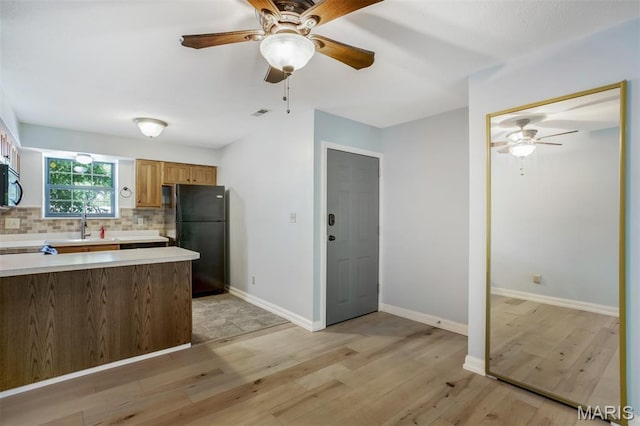 12975 Bryce Canyon Dr Unit D, Maryland Heights, MO 63043 - kitchen with freestanding refrigerator, ceiling fan, light countertops, and backsplash