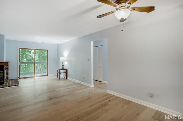 12975 Bryce Canyon Dr Unit D, Maryland Heights, MO 63043 - unfurnished living room with light wood-type flooring, ceiling fan, and a brick fireplace