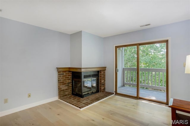 12975 Bryce Canyon Dr Unit D, Maryland Heights, MO 63043 - unfurnished living room featuring wood finished floors and a brick fireplace