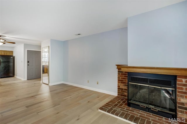 12975 Bryce Canyon Dr Unit D, Maryland Heights, MO 63043 - unfurnished living room featuring a fireplace, a ceiling fan, and light wood-type flooring