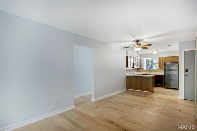 12975 Bryce Canyon Dr Unit D, Maryland Heights, MO 63043 - kitchen featuring freestanding refrigerator, stainless steel microwave, backsplash, light countertops, and a peninsula