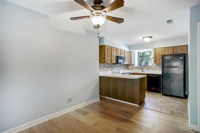 12975 Bryce Canyon Dr Unit D, Maryland Heights, MO 63043 - kitchen with black appliances, tasteful backsplash, light countertops, a peninsula, and light wood-type flooring