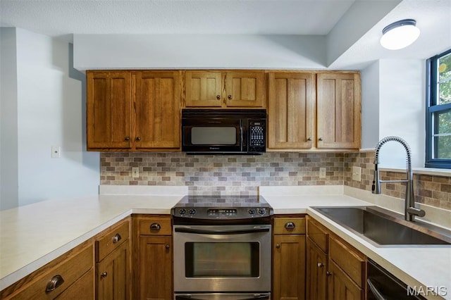12975 Bryce Canyon Dr Unit D, Maryland Heights, MO 63043 - kitchen with stainless steel range with electric cooktop, black microwave, light countertops, and brown cabinetry